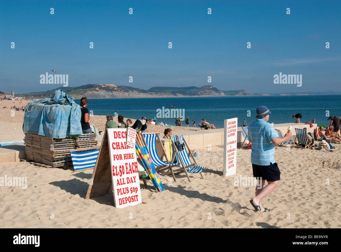 männliche Urlauber vorbeigehen Liegestühle zu mieten am Sandstrand Stockfoto