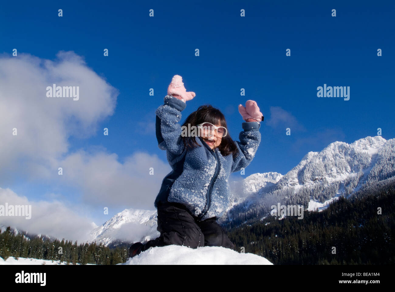 Mädchen, die Arme mit Schnee bedeckt Berge im Hintergrund. Stockfoto