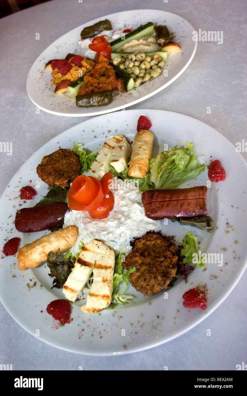 Nahaufnahme von einem Teller heiße griechische Mezze Platte (vorne) und einen Teller mit kalten Mezze (hinten) in einem modernen griechischen Restaurant in Hove. Stockfoto