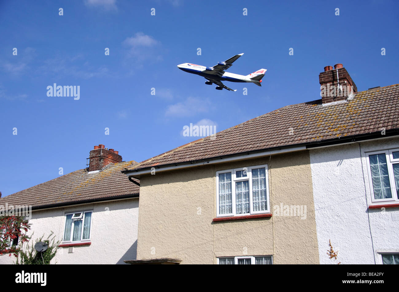 Flugzeug abheben über Häuser, Stanwell Moor, Surrey, England, Vereinigtes Königreich Stockfoto