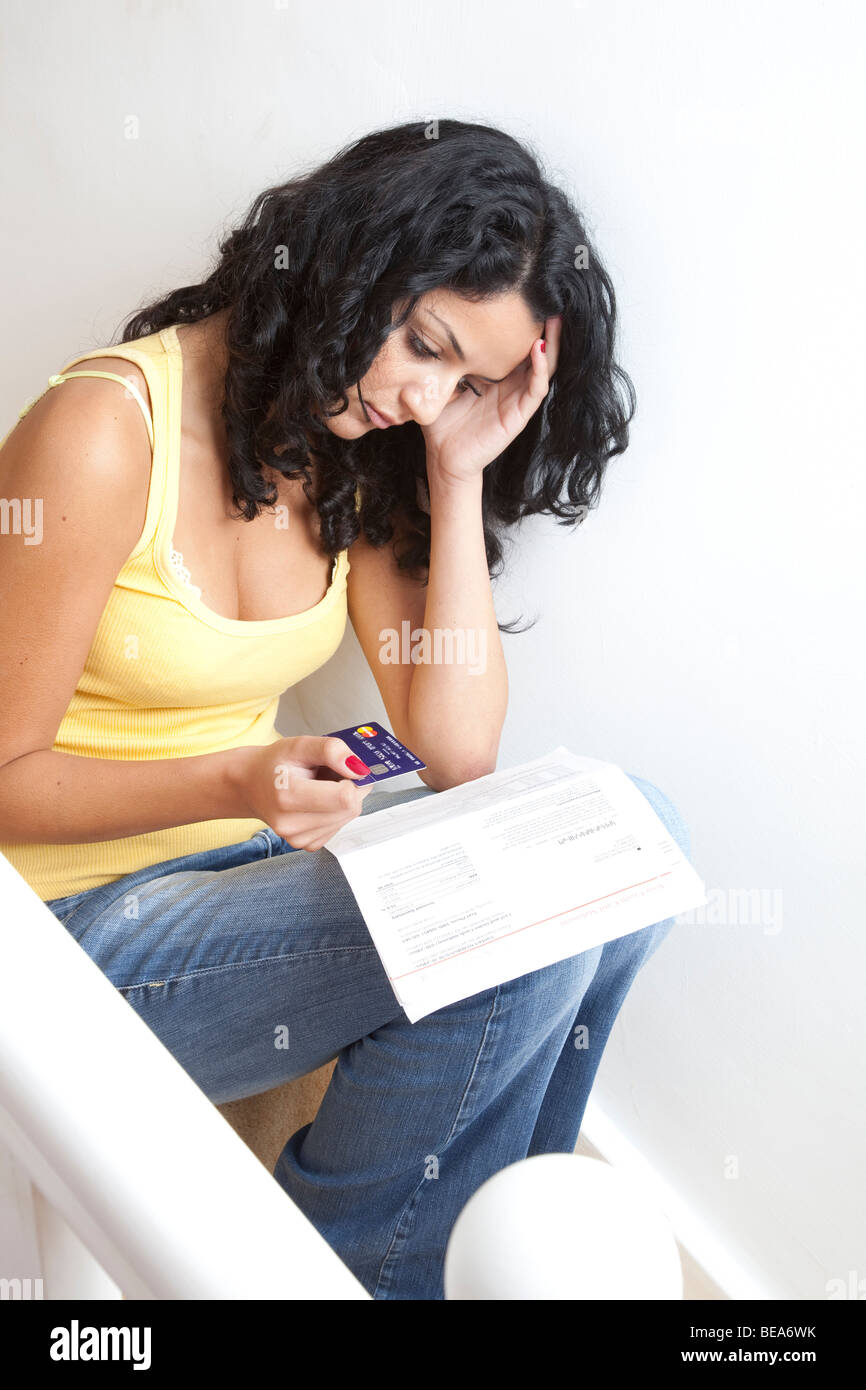Junge Frau mit einer Kreditkarte mit einem Bankauszug Stockfoto