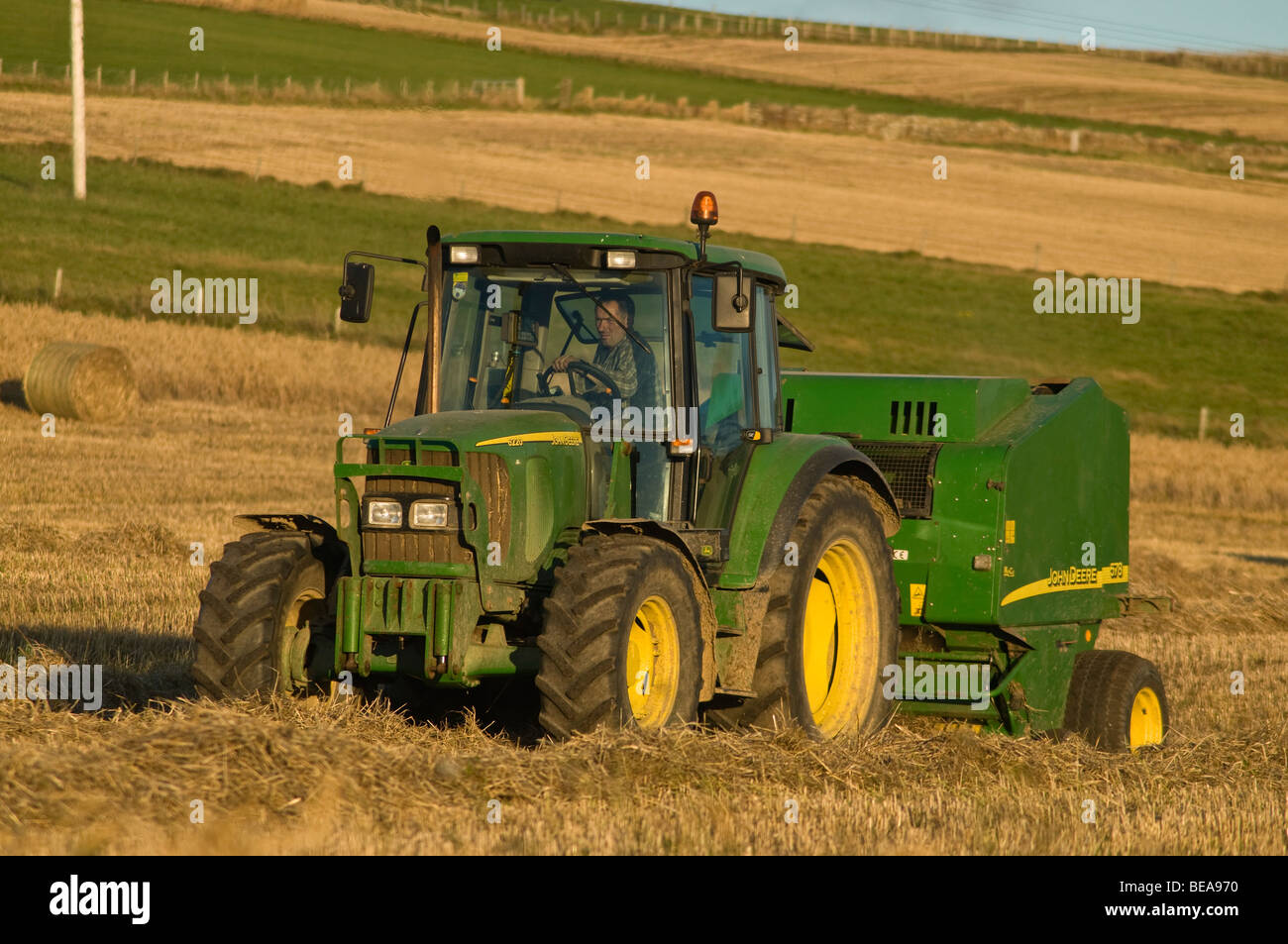 dh John Deere Traktor Ballenpresse ERNTE UK Ballenfeld Ernte Heuballen schottland Landwirtschaft Heuernte Stockfoto