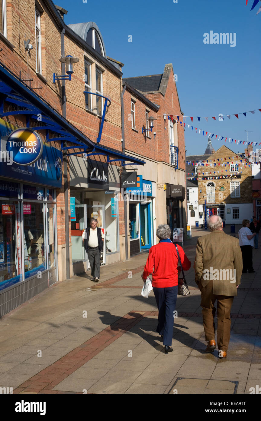 Menschen zu Fuß durch eine Fußgängerzone in Market Harborough, Leicestershire Stockfoto