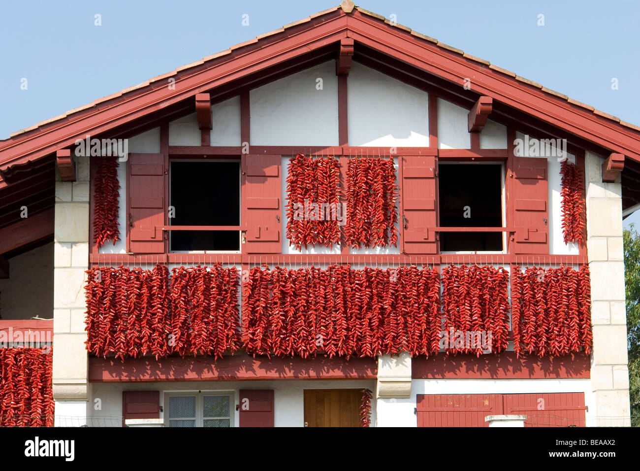 Rote Paprika Trocknung auf der Fassade eines baskischen Hauses (Espelette - Frankreich). Piments d ' Espelette Séchant En Fassade de Maison. Stockfoto