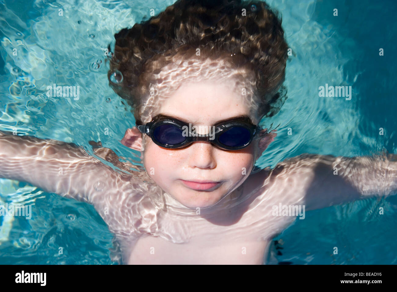 Ein kleiner Junge Schutzbrille tragen und im Wasser schwimmende Stockfoto
