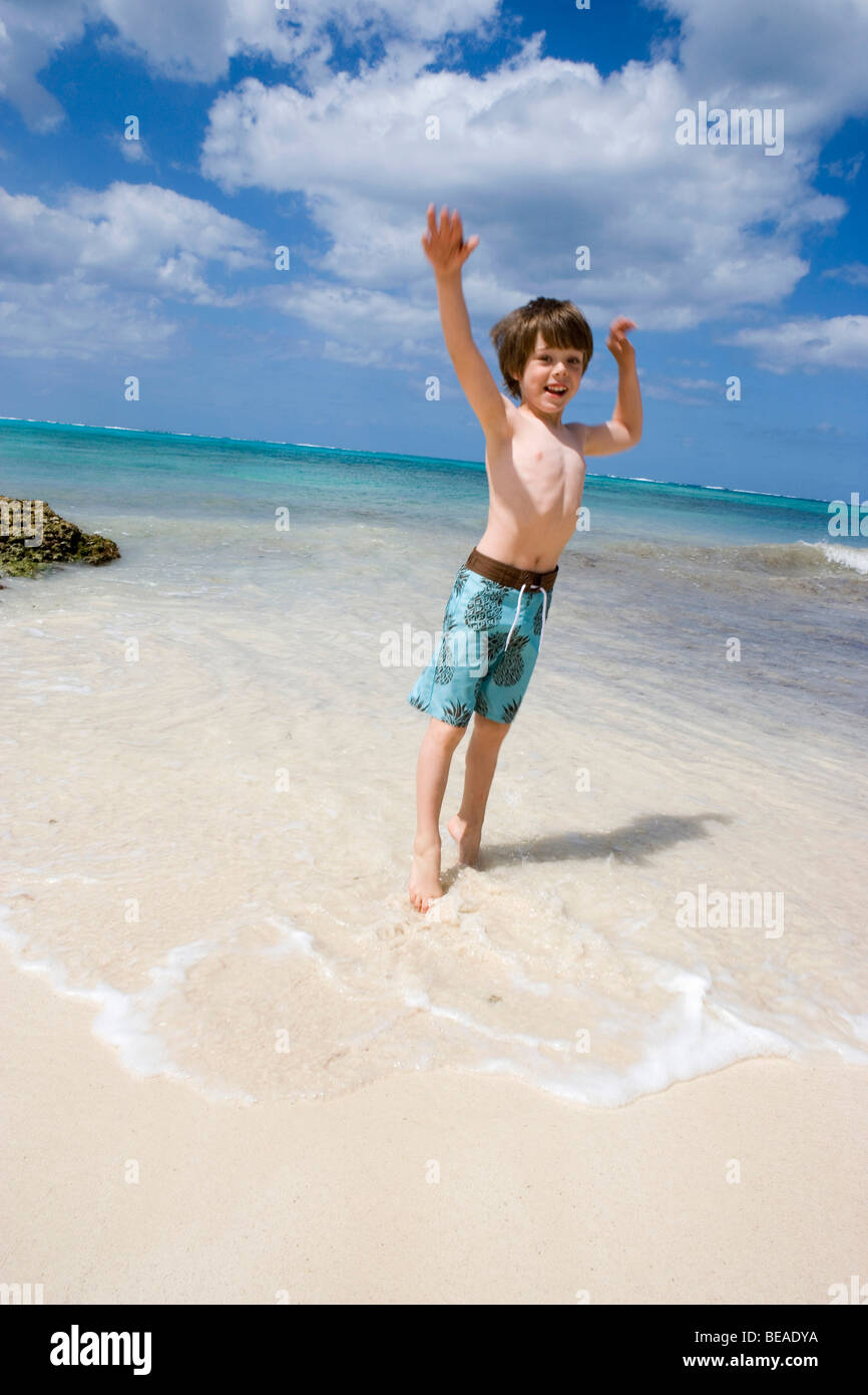 Ein kleiner Junge, springen auf der Strand, Cable Beach, Nassau, Bahamas, Karibik Stockfoto