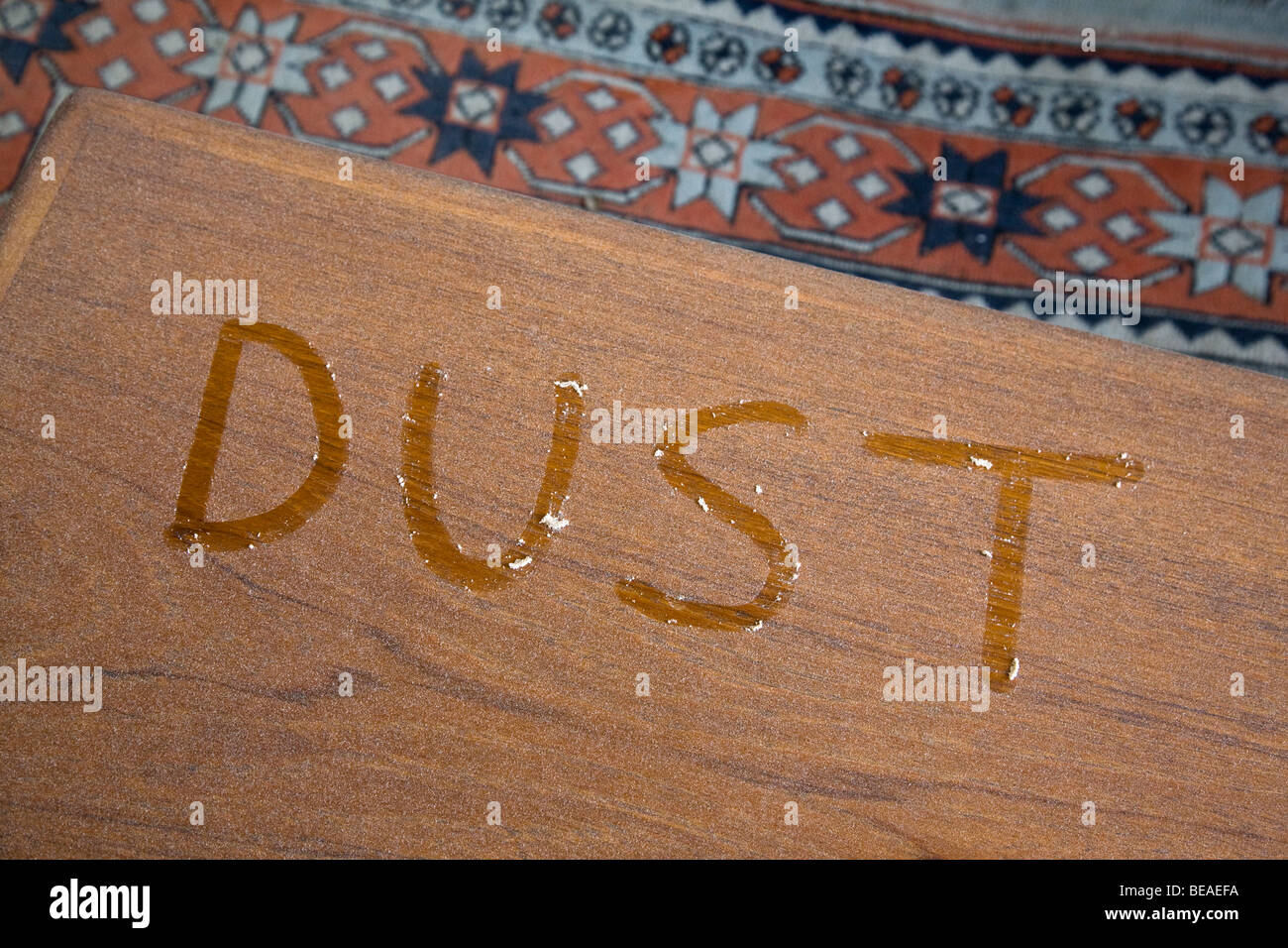 Das Wort Staub auf einem staubigen Tisch geschrieben Stockfoto
