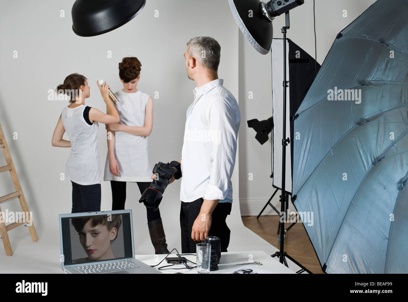 Ein Fotograf, Modell und Make-up-Künstler am Set von einem Mode-Shooting Stockfoto