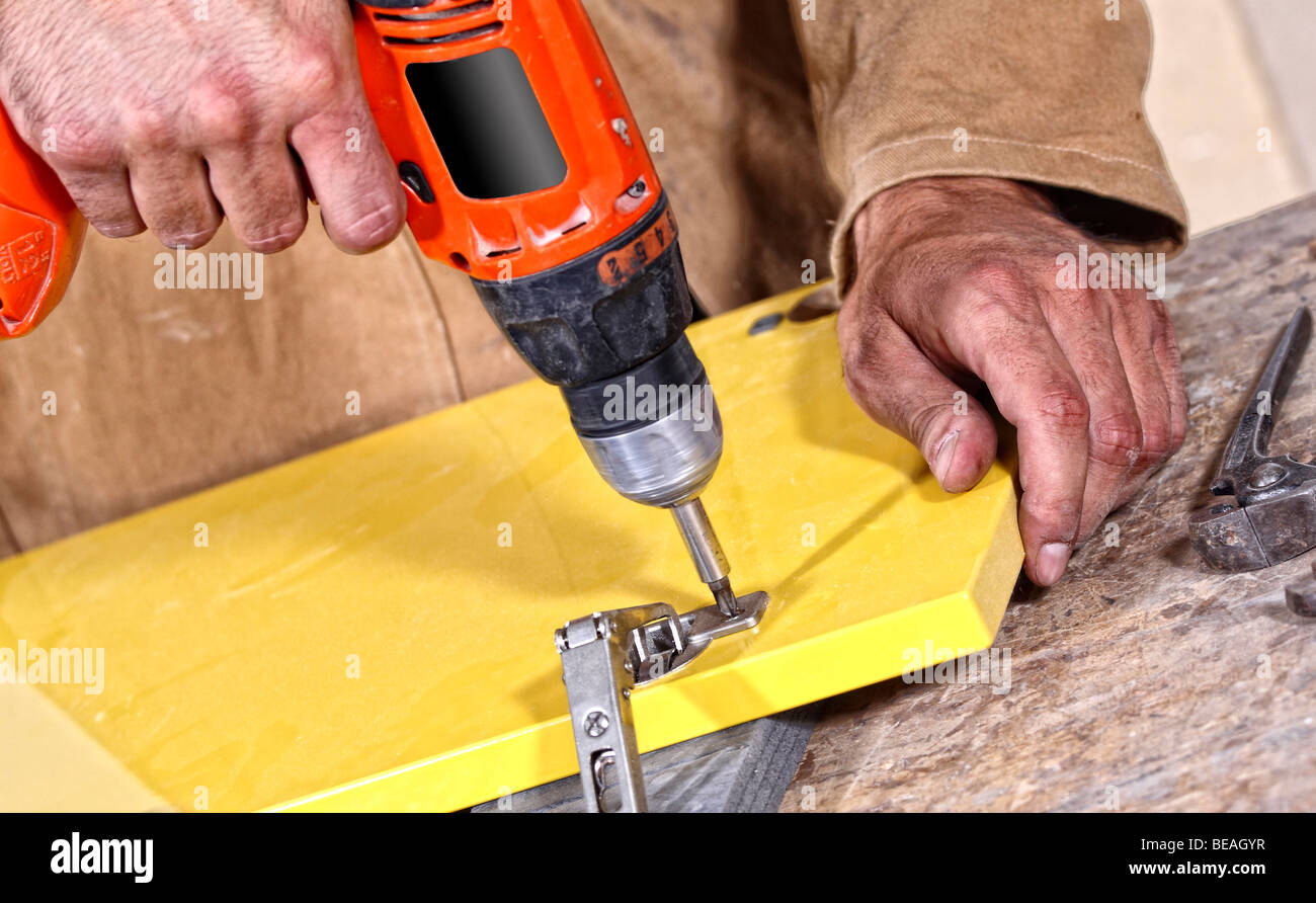 Tischler mit roten Bohrer beim Arbeiten, industriellen Hintergrund Stockfoto