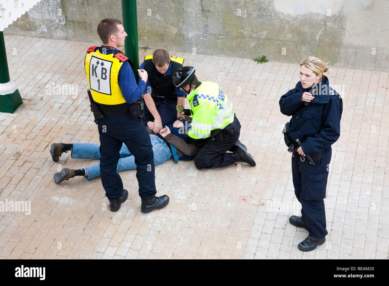Polizei verhaftet einen Mann, die Widerstand leisteten. Sie kniet auf ihm, wie sie ihm Handschellen Stockfoto