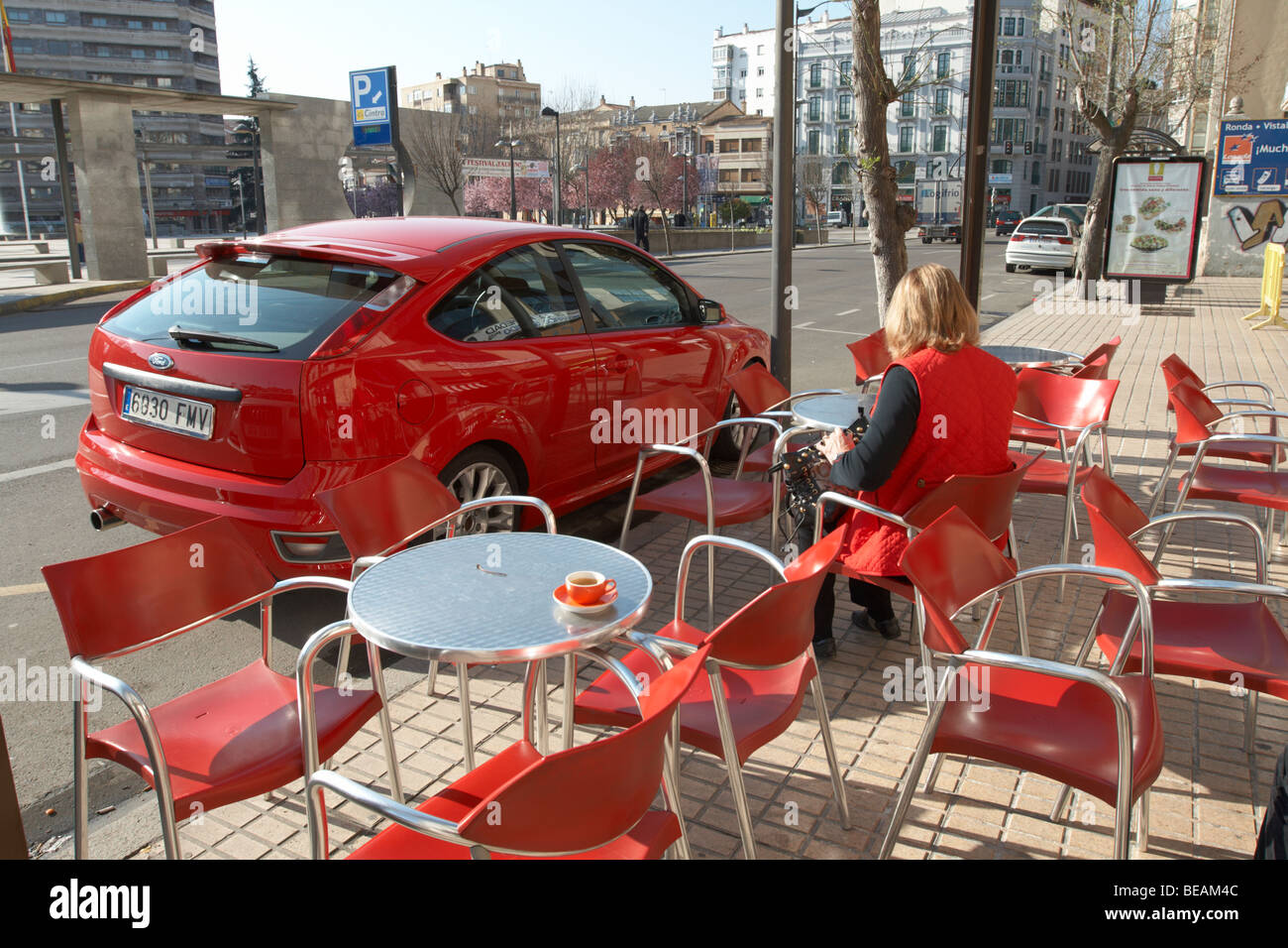 rotes Auto, Stühle und Frau trinkt Kaffee Restaurantterrasse, Zamora Spanien Kastilien und leon Stockfoto