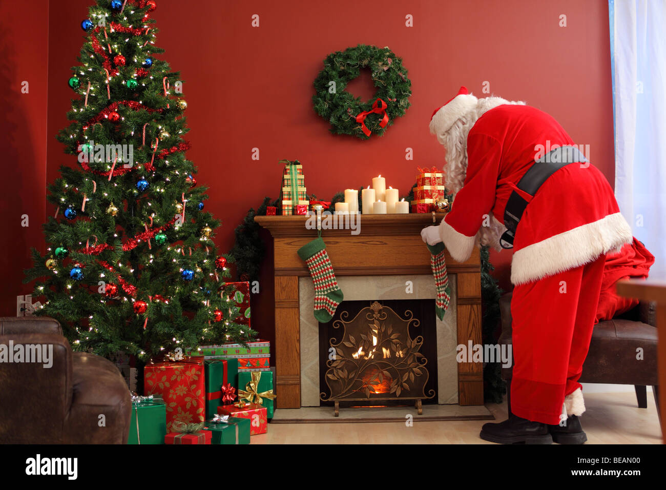 Santa Claus Weihnachtsgeschenke in Strümpfen setzen Stockfoto