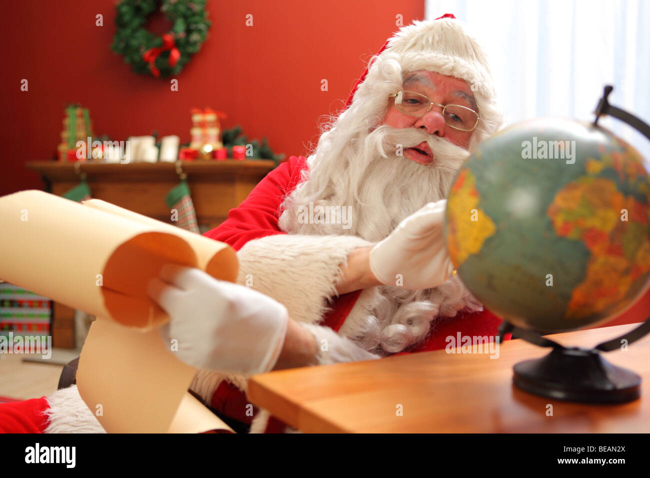 Santa Claus sieht im globe Stockfoto