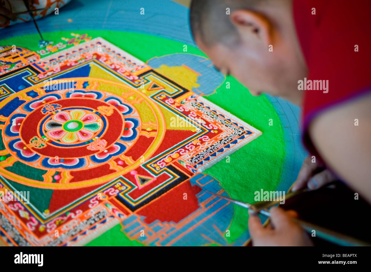 Tibetischen Mönch Yeshi Choedup arbeitet sorgfältig an einem bunten Sand Mandala in Ruidoso, New Mexico. Stockfoto