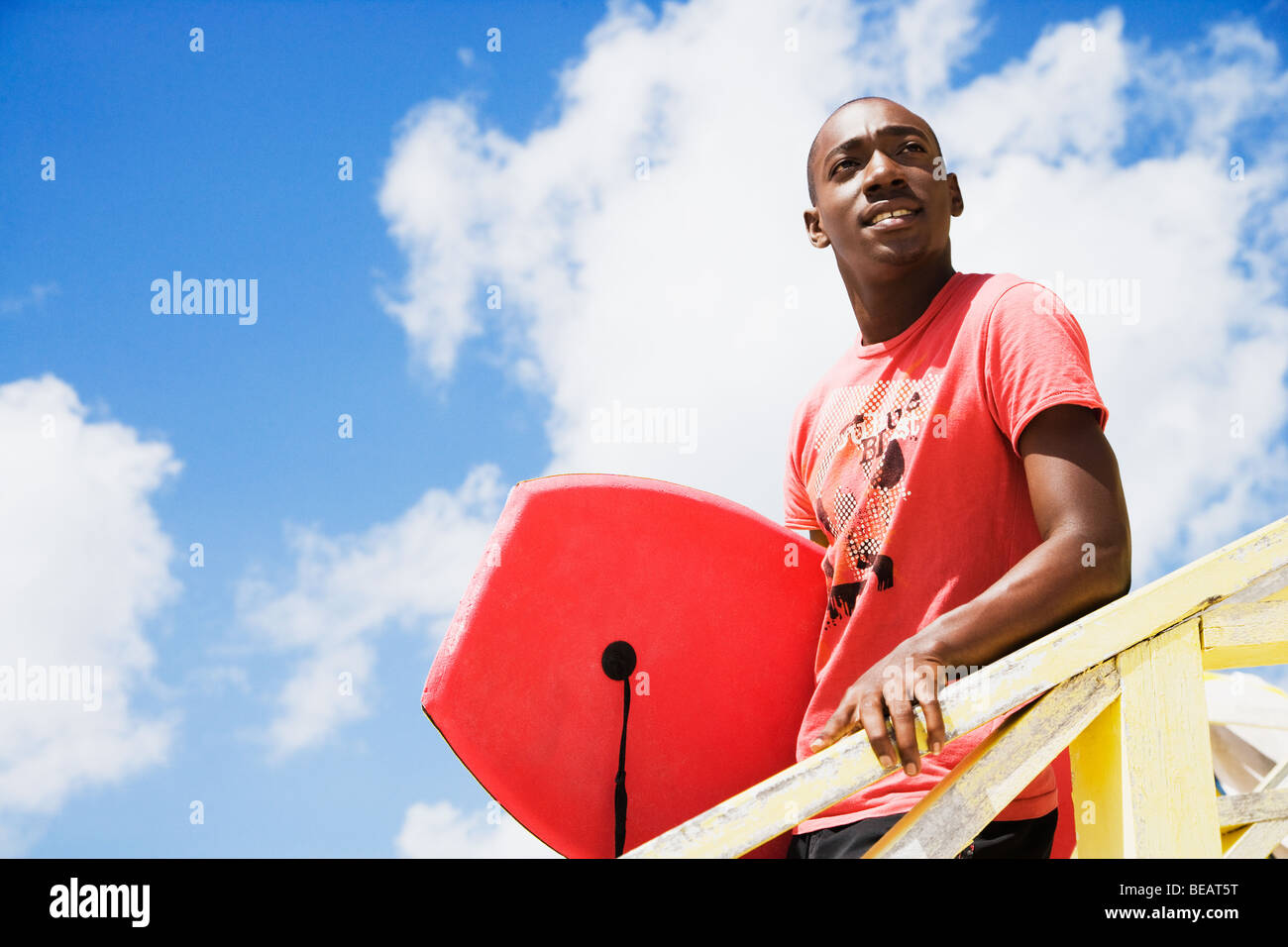 Afrikanischer Mann hält Bodyboard Stockfoto