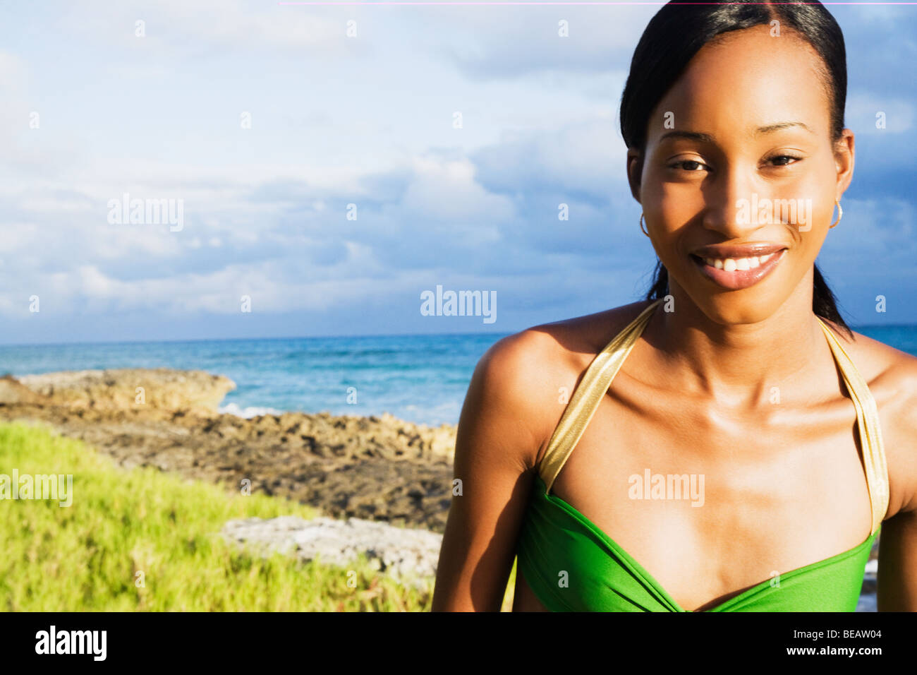 Afrikanische Frau lächelnd mit Meer im Hintergrund Stockfoto