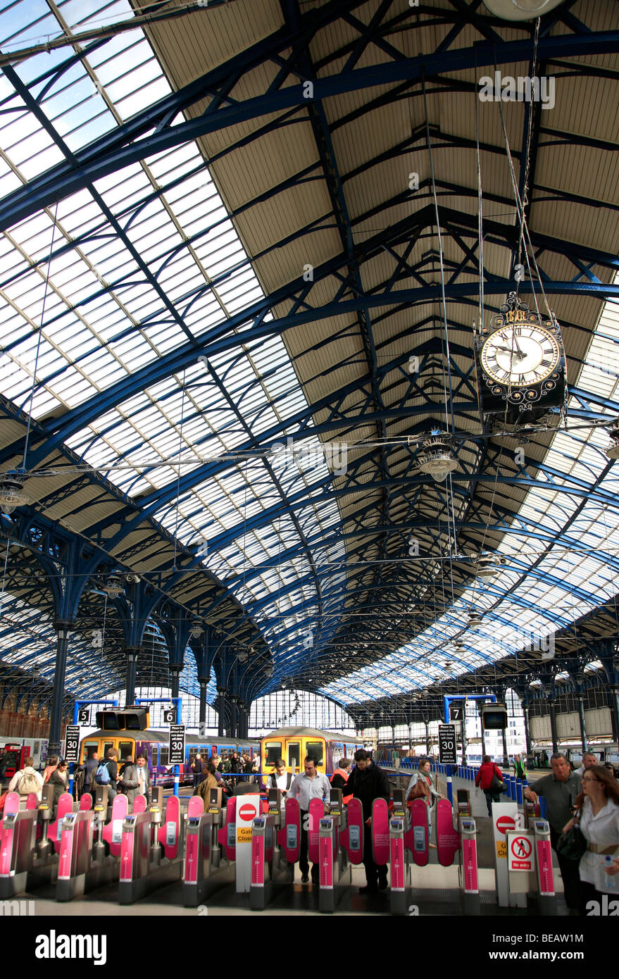 Passagier-Drehsperren und Uhr Brighton City Station Sussex England UK Stockfoto
