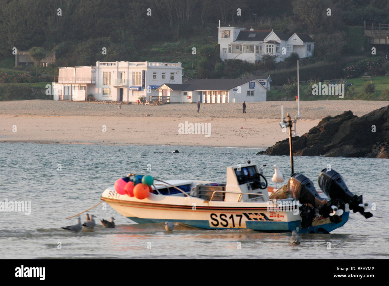 Boot bei Ebbe in St Ives Harbour mit dem Porthminster Café und Strand im Hintergrund Stockfoto