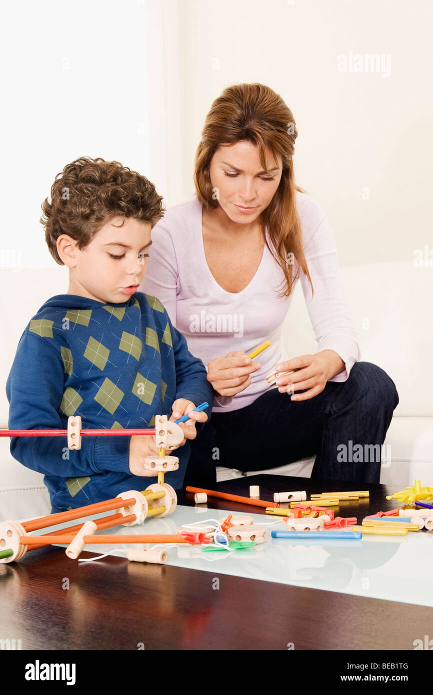 Frau, die Unterstützung ihres Sohnes bei der Montage einer Spielzeugs Stockfoto