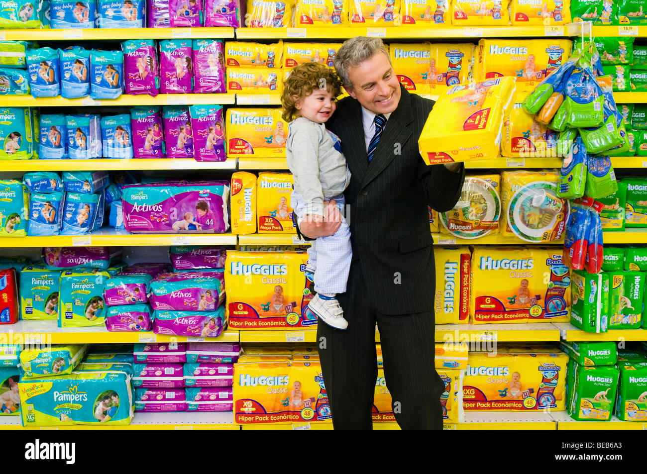 Mann, die Wahl einer Windel-Paket mit seinem Sohn in einem Supermarkt Stockfoto