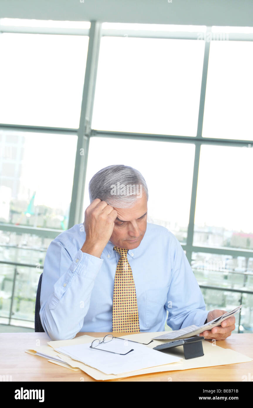 Geschäftsmann, lesen Zeitung an seinem Schreibtisch im Büro Stockfoto