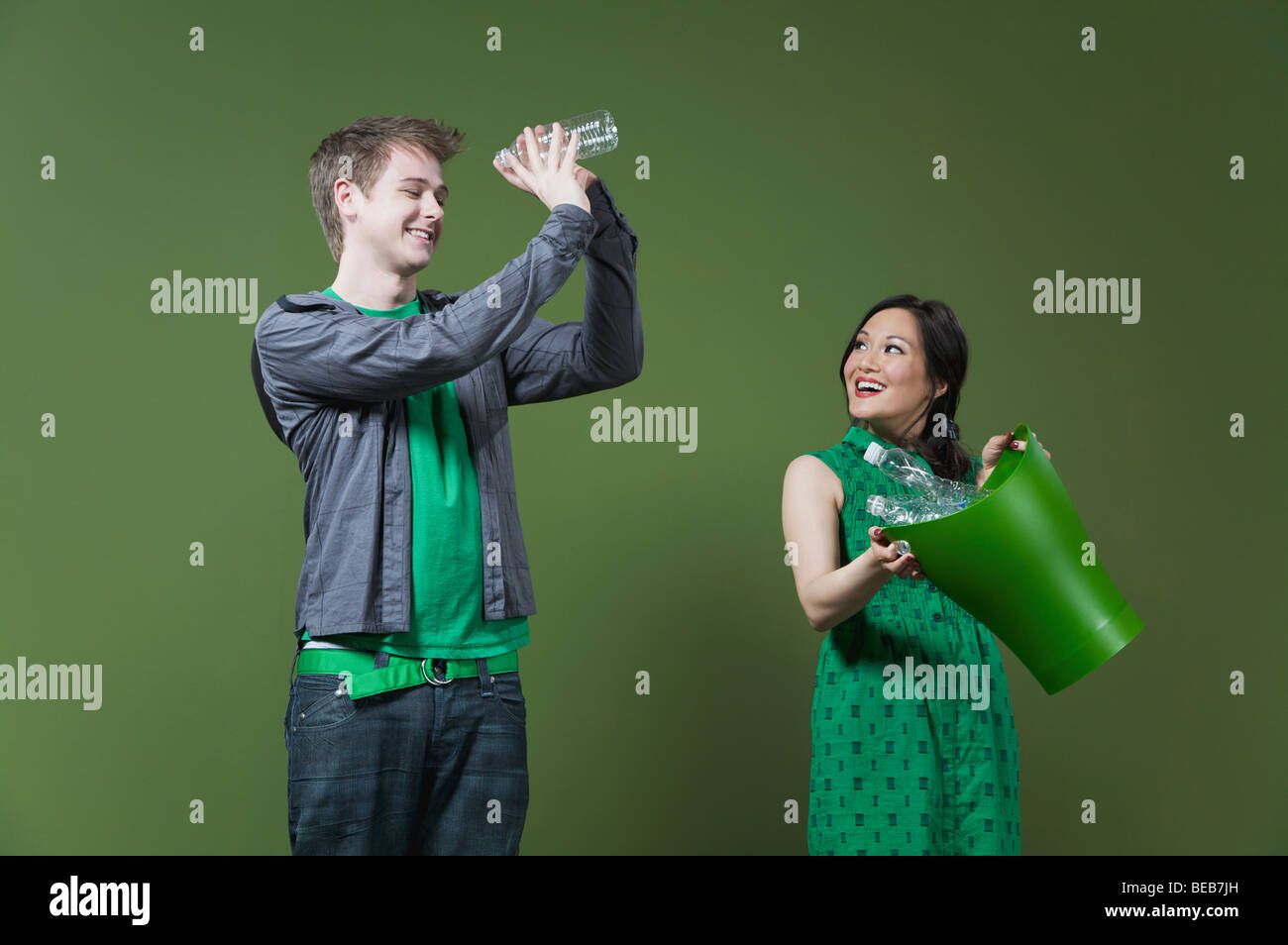 Frau hält ein Papierkorb und ein Mann in eine leere Wasserflasche Stockfoto