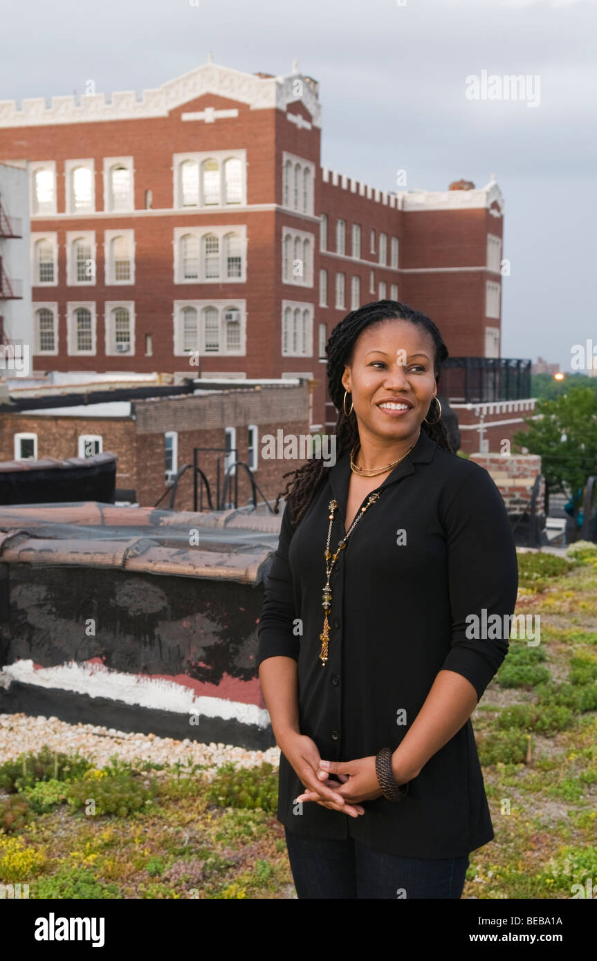 Urbane Revitalisierung Stratege, Majora Carter auf ihrem grünen Dach in der South Bronx, mit ihrer Kindheit Schule hinter ihr. Stockfoto Urbane Revitalisierung Stratege, Majora Carter auf ihrem grünen Dach in der South Bronx, mit ihrer Kindheit Schule hinter ihr. Stockfoto