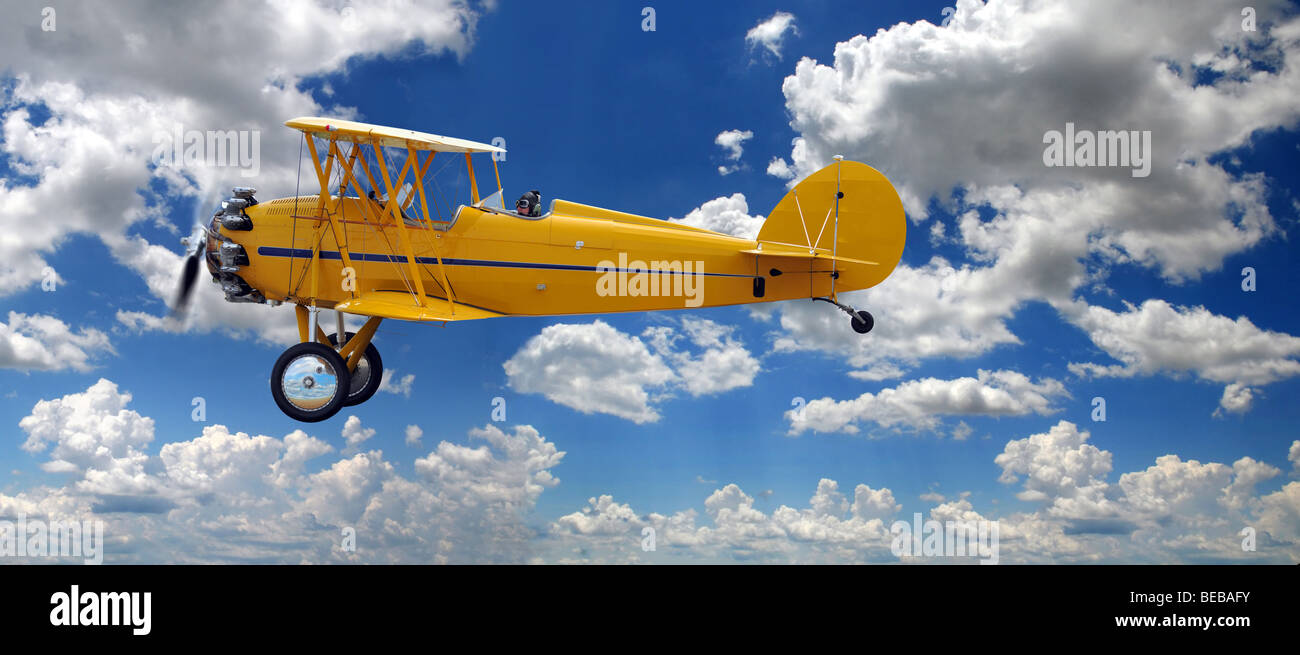 Oldtimer Doppeldecker über richtige Wolken an einem sonnigen Tag Stockfoto