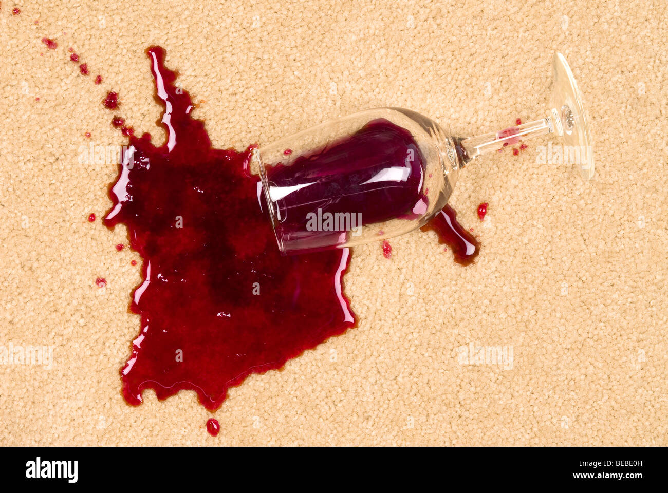 Ein Glas verschüttete Wein auf neue Teppich ist einen Fleck hinterlassen. Stockfoto