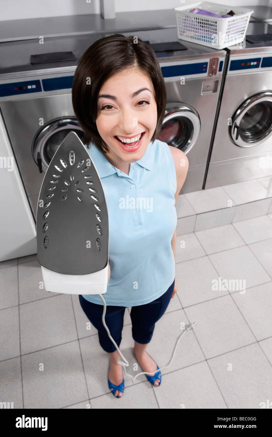 Porträt einer Frau hält Eisen und lächelnd Stockfoto