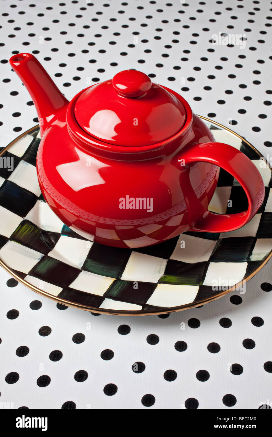 Rote Teekanne auf Schachbrett Teller Stockfoto