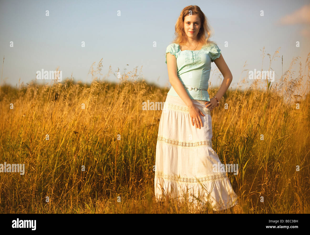 Junge Frau auf einer Sommerwiese. Roten Abendlicht. Stockfoto