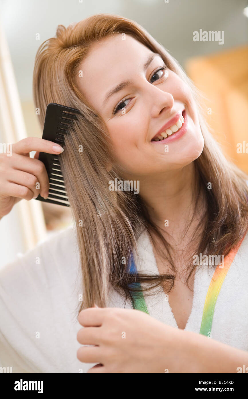 Junge Frau Bürsten Haare im Bad. Stockfoto