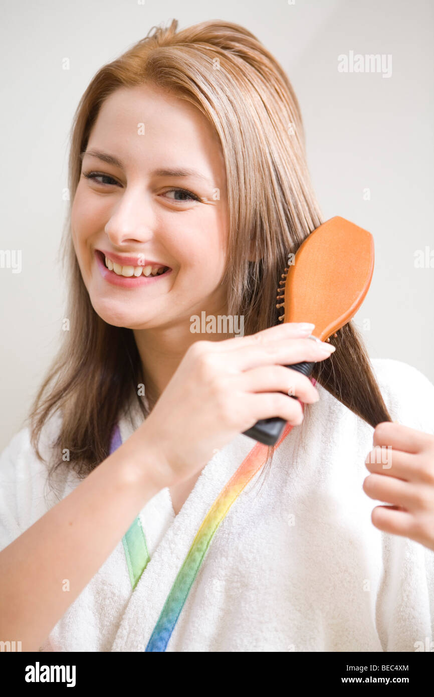Junge Frau Bürsten Haare im Bad. Stockfoto