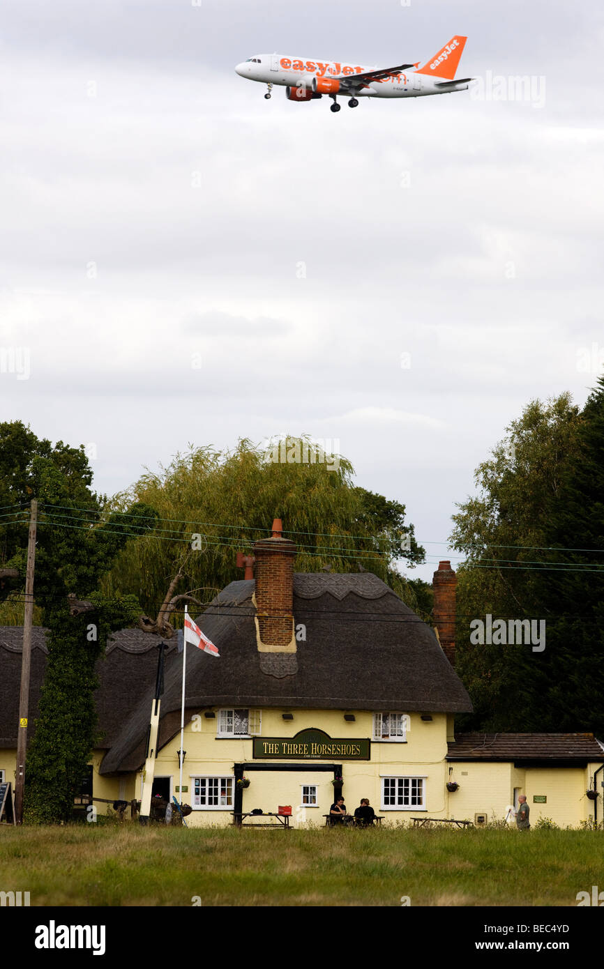 Einem Easyjet-Passagier-Jet über The Three Horseshoes Pub in Maulwurfshügel grün, Essex, auf dem Weg zum landen am Flughafen Stansted Stockfoto