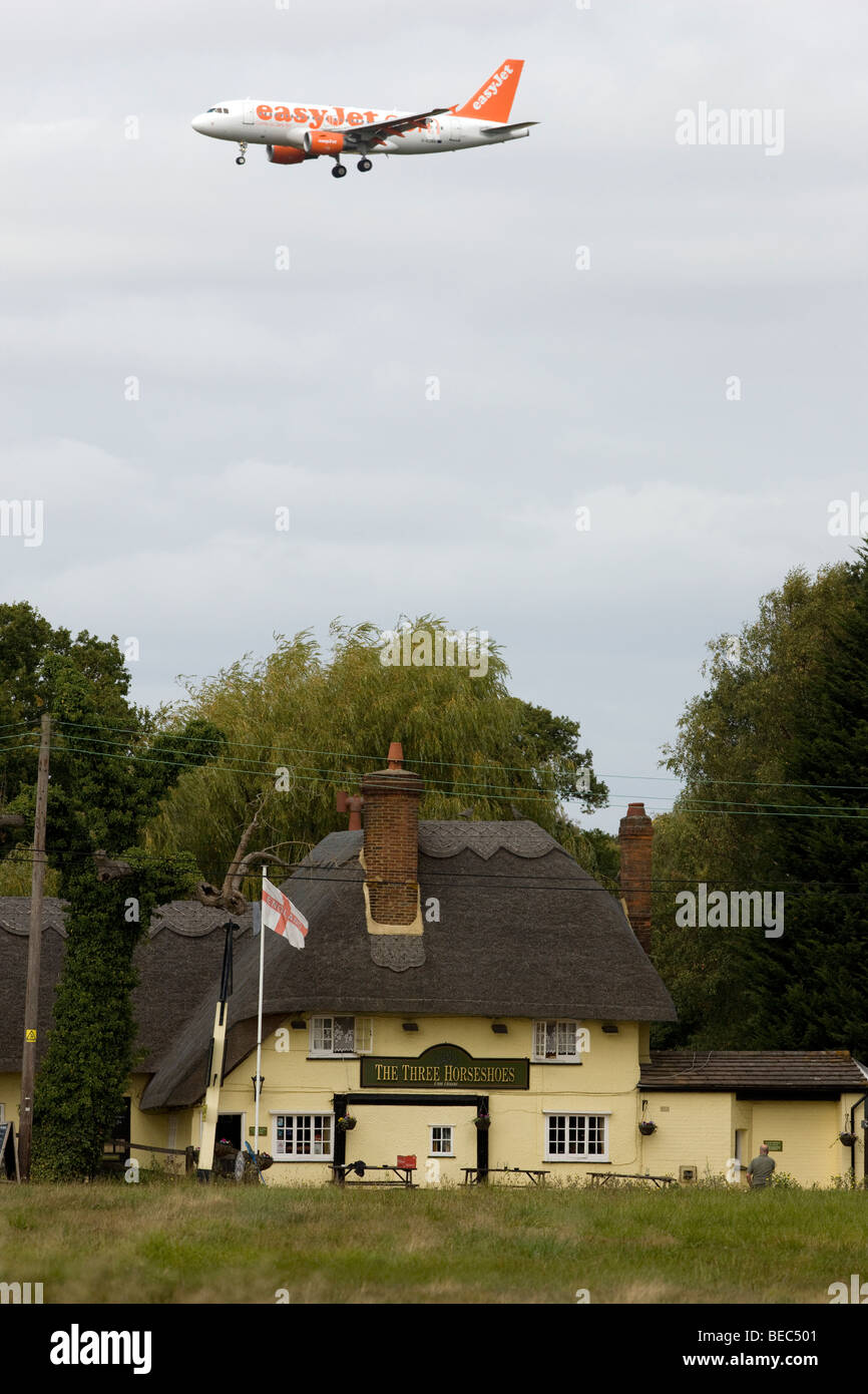 Einem Easyjet-Passagier-Jet über The Three Horseshoes Pub in Maulwurfshügel grün, Essex, auf dem Weg zum landen am Flughafen Stansted Stockfoto