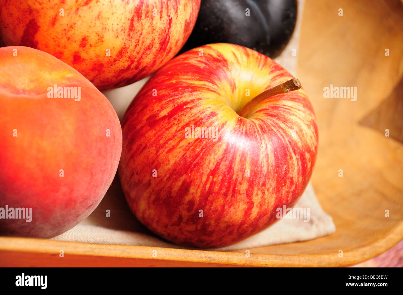 Gala Äpfel mit gelben Pfirsichen und Schwarze Pflaume. Stockfoto