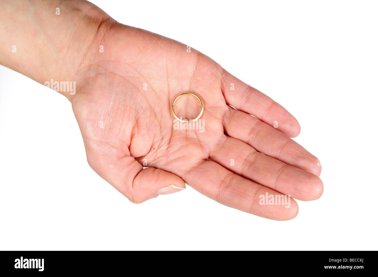 Zarte Frauenhand hält einen Ehering in ihre Handfläche Stockfoto