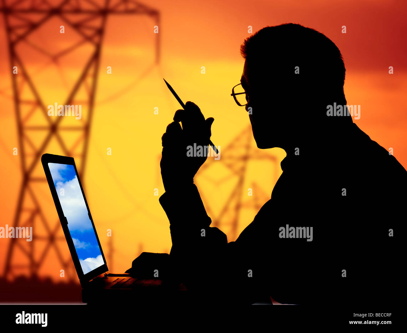 Mann mit Laptop-Computer suchen Fenster an Strommasten Silhouette bei Sonnenuntergang Stockfoto