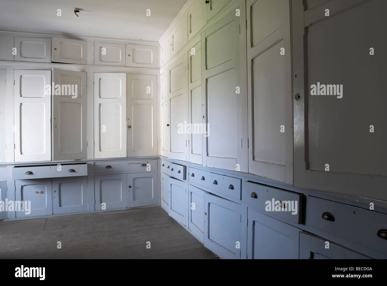 Stillgelegten Bettwäsche Zimmer mit weißen und blauen Schränken in alten englischen Herrenhaus Stockfoto