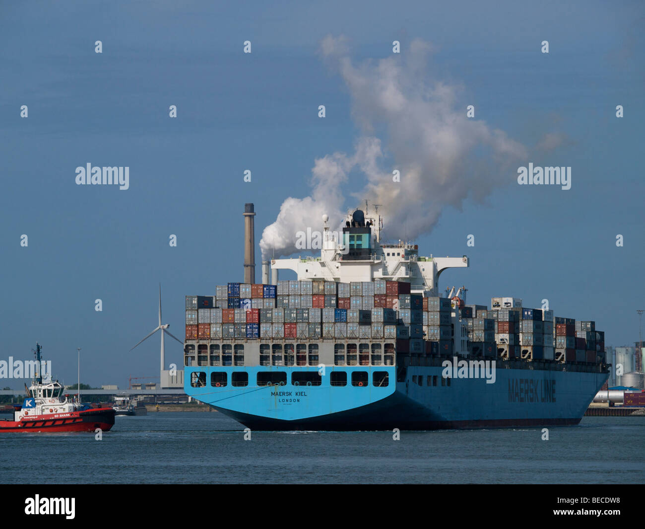 Das sehr große Maersk Kiel Containerschiff manövriert wird durch einen Schlepper im Hafen von Rotterdam, Zuid Holland, Niederlande Stockfoto