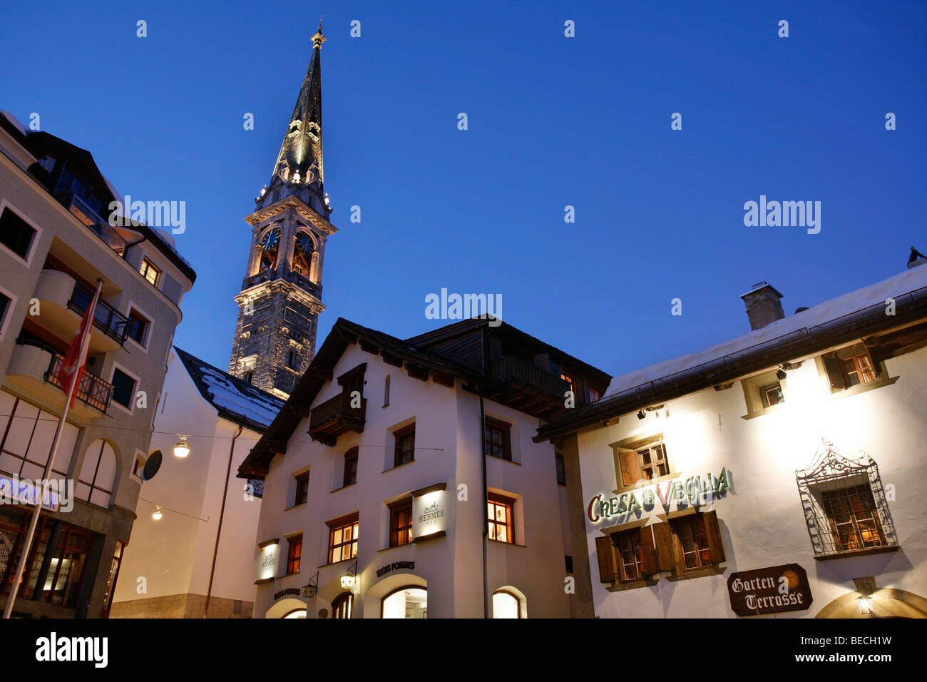 Chesa Veglia, alte Restaurant und beleuchteten Dorfkirche am Abend, St. Moritz, Oberengadin, Symbole, Schweiz Stockfoto