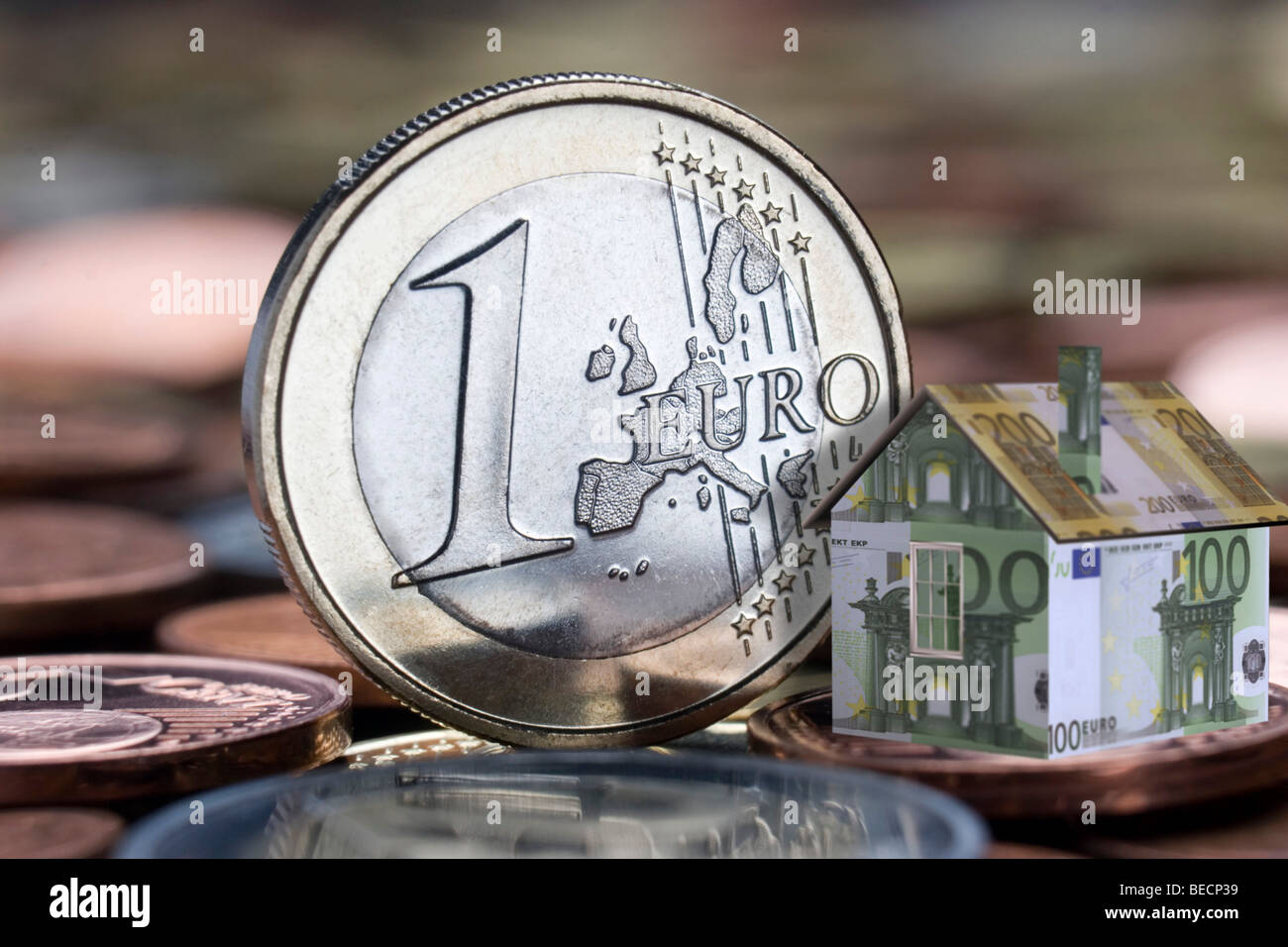 Geld und ein Miniaturhaus Stockfoto