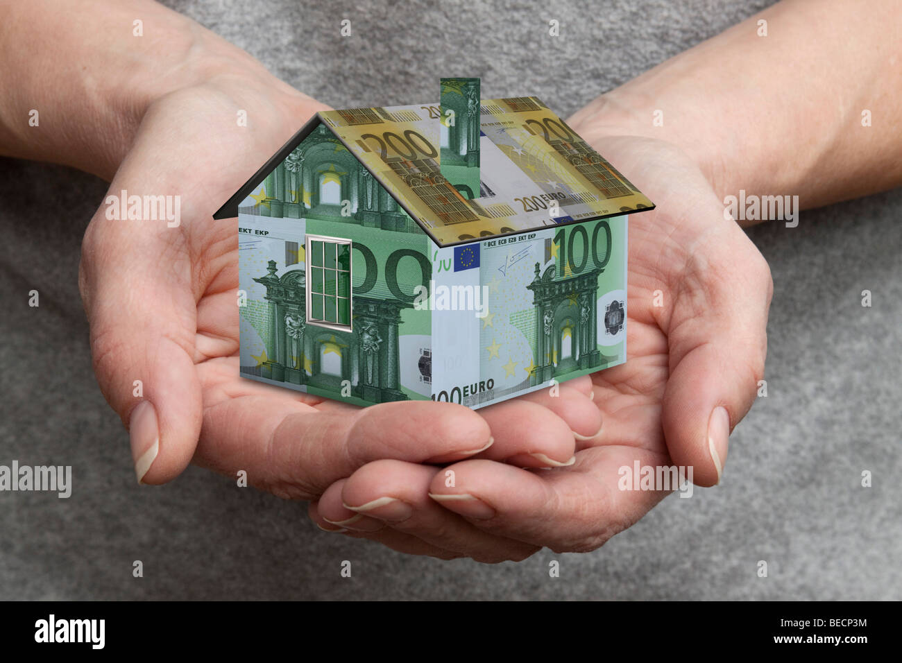 Hände halten ein Miniaturhaus Stockfoto