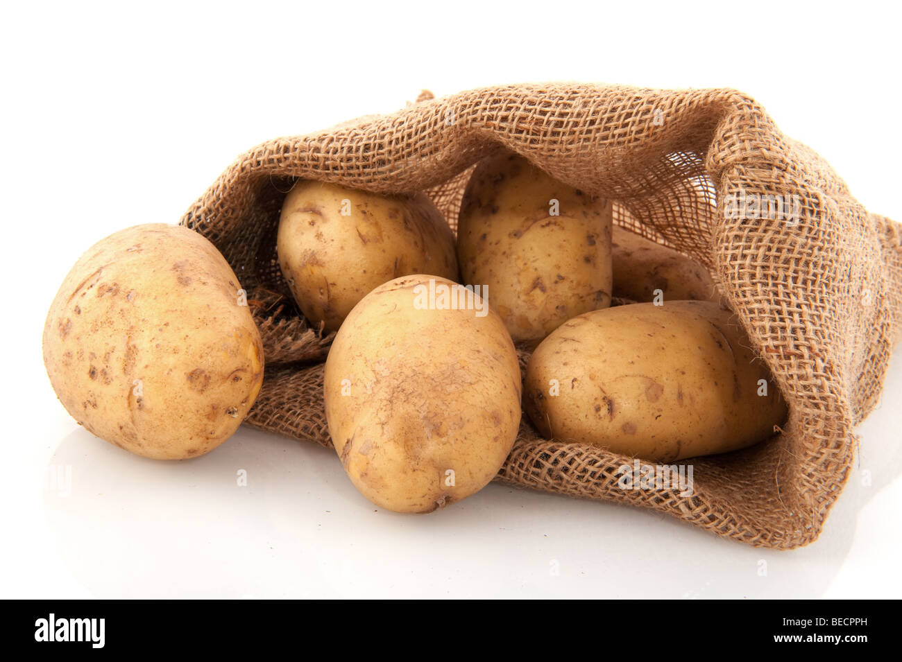 Jute-Tasche mit Kartoffeln isoliert auf weiß Stockfoto
