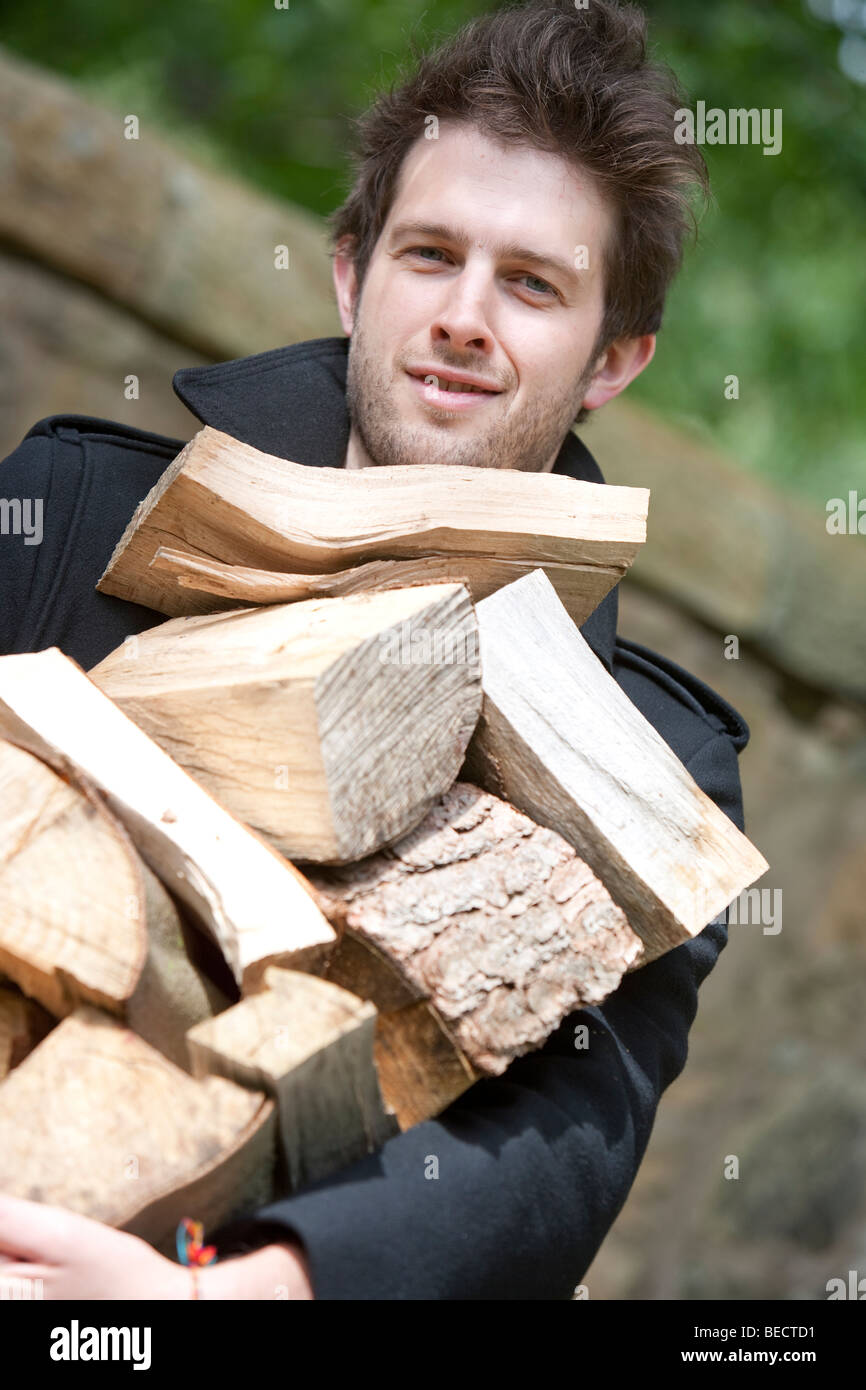 Mann hält einen Haufen Brennholz Stockfoto