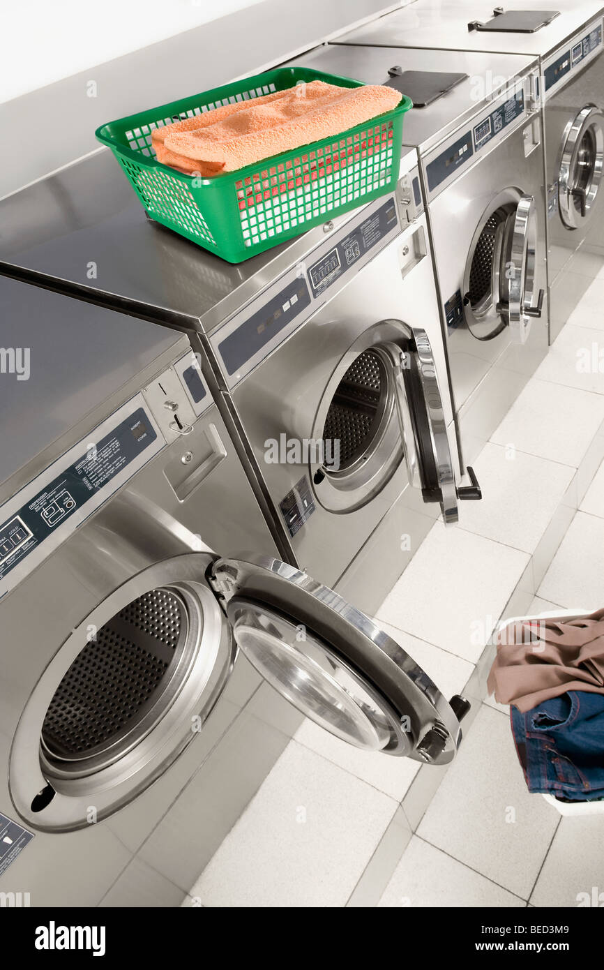Wäschekorb auf eine Waschmaschine in einem Waschsalon Stockfotografie