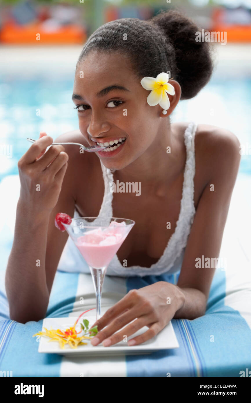 Porträt einer Frau liegen am Pool und Eis essen Stockfoto