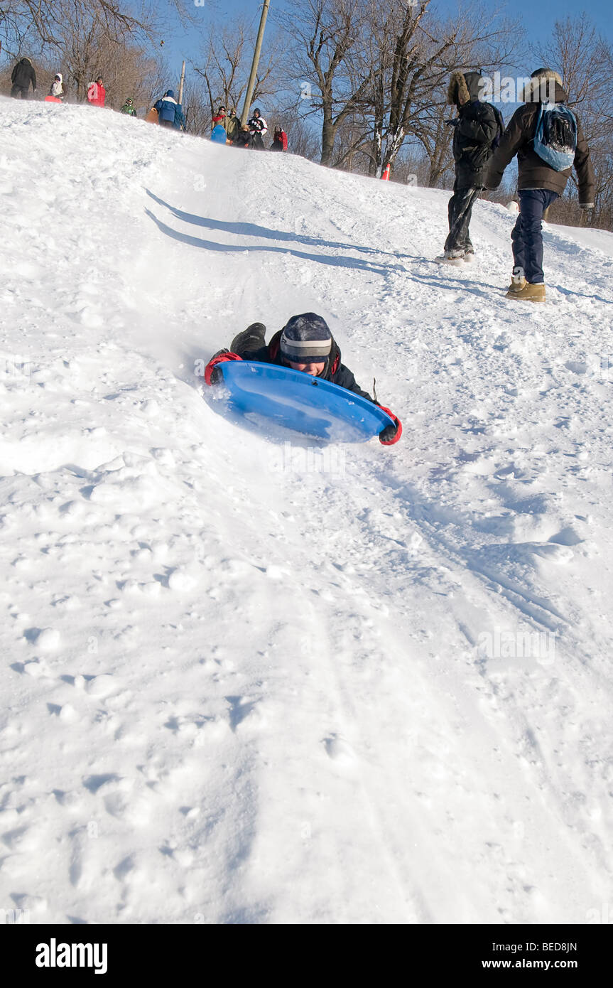 Kind im Schnee bergab schieben Stockfoto