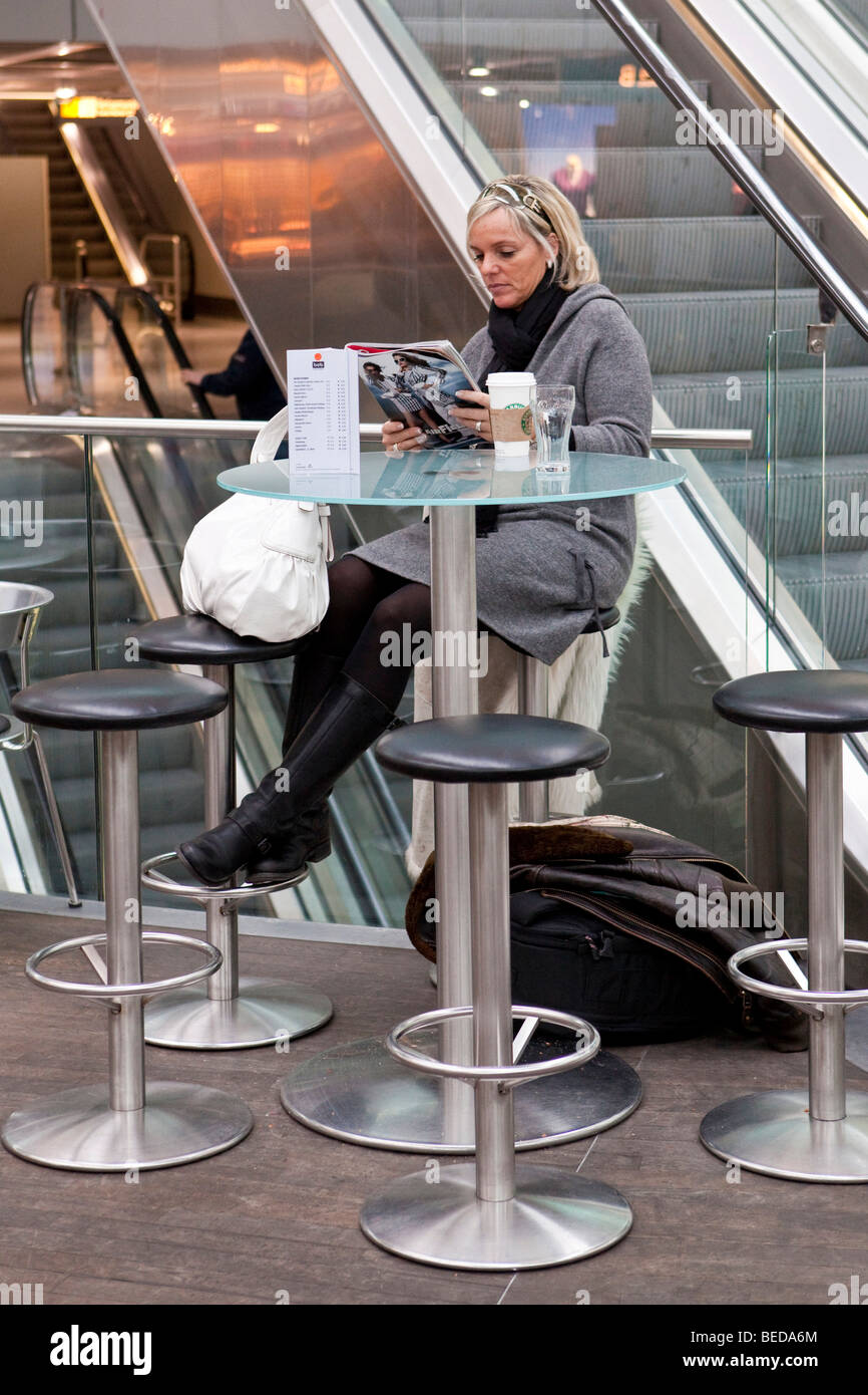 Frau liest eine Zeitschrift in der Abflughalle am Flughafen Düsseldorf, Düsseldorf, Nordrhein-Westfalen, Deutschland, Europa Stockfoto